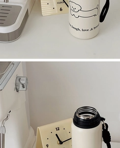 Detail of cream stainless steel bottle with cartoon dog design and carrying strap