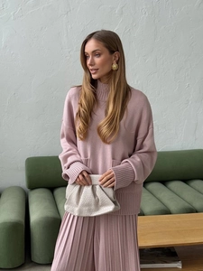 Detailed knit texture of the mauve pink turtleneck sweater and pleated skirt set