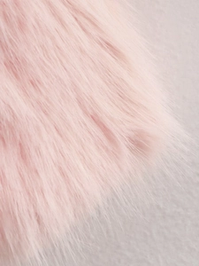 Gros plan détaillé montrant la texture douce de la fourrure synthétique rose