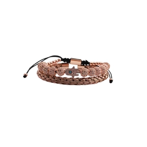 Macro shot of rose gold Hamsa hand charm bracelet and braided bangle with cubic zirconia