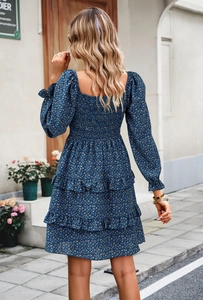 Back view of blue floral long sleeve mini dress with layered ruffle hem and waist detail