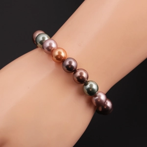 Detailansicht von rosa, grauen und orangefarbenen Muschelperlen auf dem Armband
