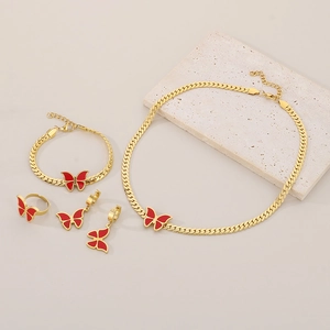 Detail of red butterfly jewelry set including gold necklace, bracelet, ring, and earrings