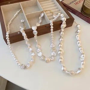 Three irregular baroque pearl necklaces with heart pendants and gold chain detail
