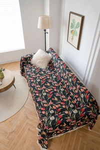 Detail of floral sofa cover featuring navy tulip patterns and delicate white fringe edges