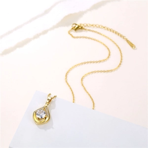 Minimalist gold teardrop necklace featuring a central clear gem with small diamond accents