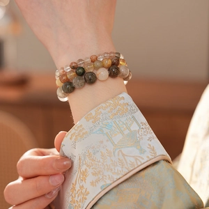 Détail de bracelets multicouches en quartz rutilé avec textures naturelles sur le poignet