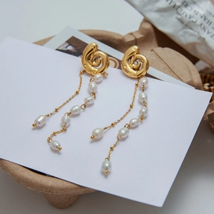 Elegant gold spiral pearl tassel earrings displayed on a minimalist white card