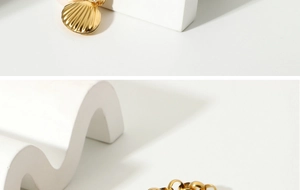 Detail of 18K gold plated chain bracelet with a delicate shell pendant on white stone