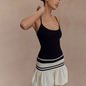 Robe moulante dos nu sexy avec haut noir et jupe plissée blanche contrastée chic
