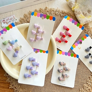 Detail of heart checkered hair clips in candy colors on white cardboard display