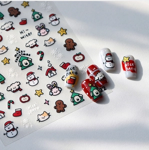 Detail von Weihnachts-Nagelstickern mit Schneemann- und Baummustern auf weißem Grund