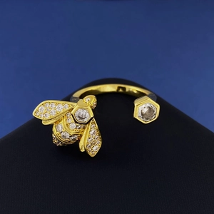 Golden bee open ring with sparkling cubic zirconia on a black matte stand