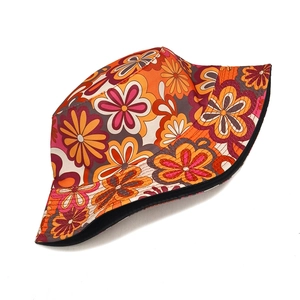Close-up of retro floral bucket hat with orange and purple patterns on a white background