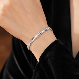 Detail of multi-layered silver mesh bracelet with crystal pavé on dark background