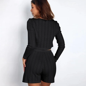 Detail of black knit loungewear set featuring ribbed texture and cutout hollow patterns