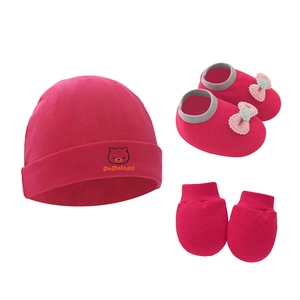 Detailed view of dark pink baby set featuring a knit hat, bow shoes and cotton mittens