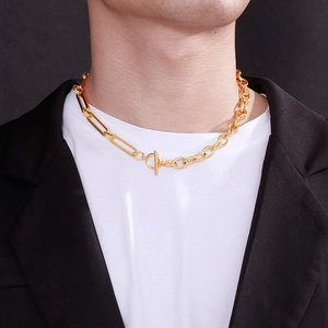 Close-up of gold OT buckle chunky link necklace worn on neck by male model in a suit