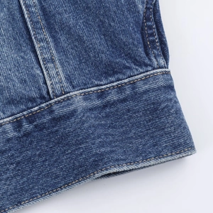 Close-up of blue denim jacket showing premium stitching and fabric texture