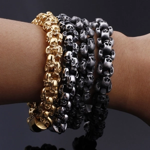 Detailed macro view of skull-shaped metal bracelets in gold, silver, and black finishes