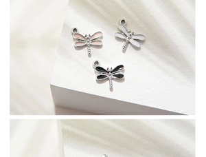 Close-up of glitter dragonfly charms in pink, white and black alloy with oil drip finish