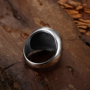 Detailed view of heavy vintage silver ring with woven geometric texture on wooden surface