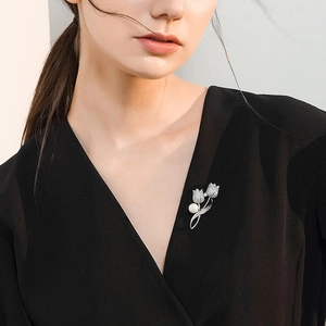 Close-up of tulip brooch with silver metal, sparkling rhinestones and white pearl detail