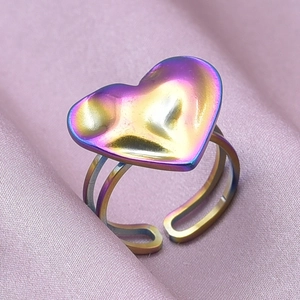 Macro shot of colorful rainbow electroplated heart ring on elegant pink silk fabric