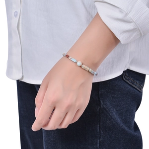 Macro detail of natural stone beaded bracelet with rectangle gems on a model's wrist