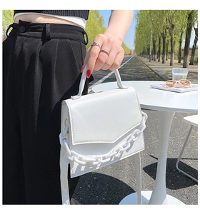 Detail shot of a white fashion square bag featuring thick chain decor and PU texture