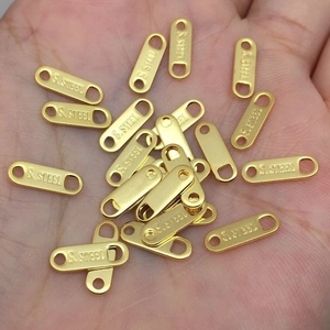 Macro view of gold-plated stainless steel tags with S.STEEL engraving for DIY jewelry