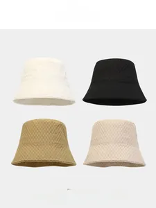Macro detail of foldable waffle texture bucket hats in black, white, khaki, and beige
