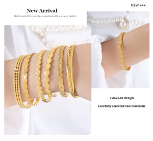 Close-up of gold hip-hop bangle set featuring heart charms and textured geometric links