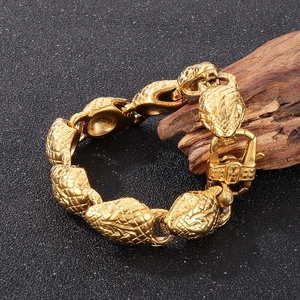 Detailed macro view of 18k gold-plated stainless steel snake head bracelet with scales