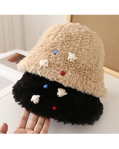 Close-up of plush knit bucket hats with cute bear patches and colorful bead accents