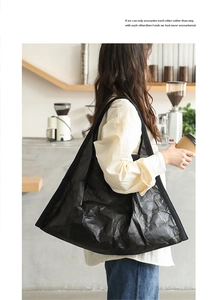 Detail of black large capacity tote bag with unique wrinkled texture shown in lifestyle use
