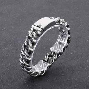 Detailed close-up of a silver stainless steel Cuban link bracelet with a dragon clasp