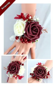 Macro detail of burgundy and cream bridal wrist corsage with berries and satin ribbons