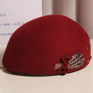 Close-up of wine red wool beret with crystal wheat ear decor and beaded bow detail
