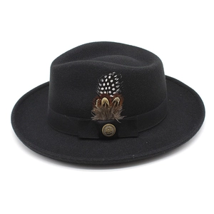 Detail of black wool fedora hat with vintage bronze buckle and decorative feathers