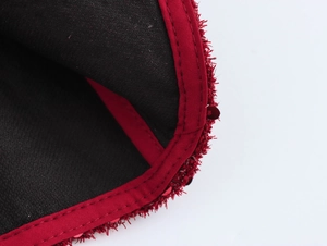Dettaglio della fodera nera e del bordo rosso in peluche testurizzato della giacca