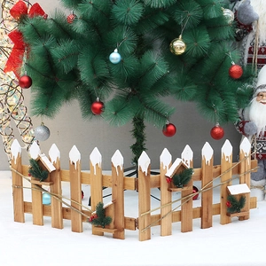 Détail de la clôture de Noël en bois avec sommet enneigé, aiguilles de pin et baies rouges