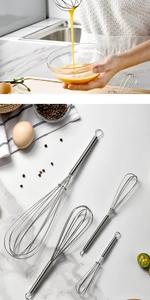 Detail of stainless steel wire whisks on white marble with professional baking ingredients