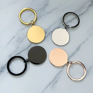 Polished round metal keychains in gold, silver, black and rose gold on marble surface