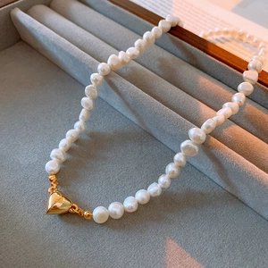 Close-up of fresh water pearl necklace with golden heart magnetic clasp in jewelry box