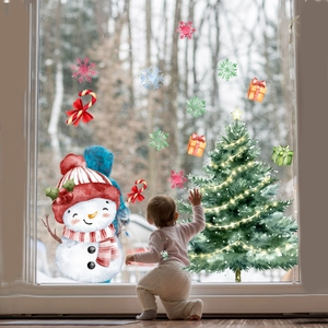 Toddler interacts with snowman and Christmas tree static window decals in a cozy home