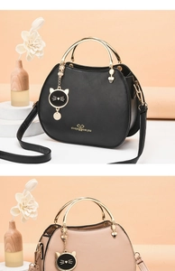 Detail view of stylish shell bags in black and beige with gold handles and cat charms