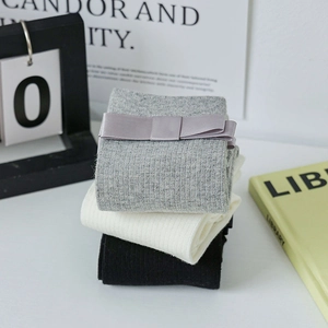 Detailed view of stacked ballet style JK mid-calf socks in grey, white and black colors