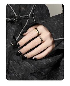 Close-up of S925 sterling silver ring with black and gold irregular texture on a hand