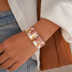 Détail du bracelet argenté avec motifs de fleurs en émail rouge, orange et jaune